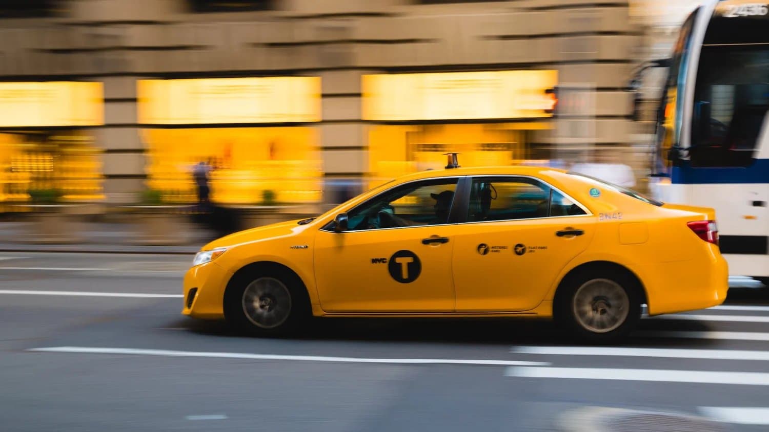 A taxi moving through city traffic